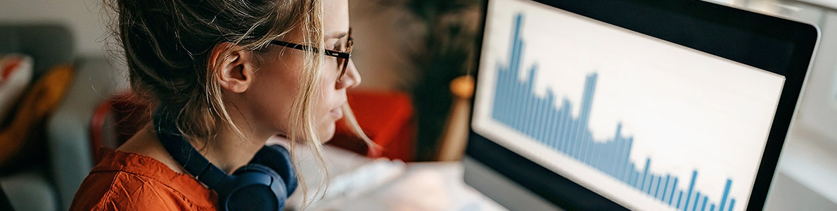 Kvinde analyserer data på computer